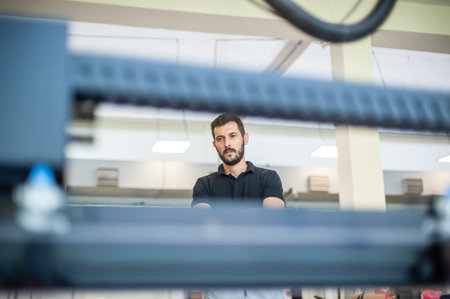Professional worker printmaker technician operator works in printing press hall and printshop office...
