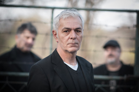 Portrait of urban and handsome fashionable artist guy pose in black elegant suits outdoorの写真素材