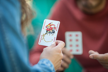 Playing cards in the spring garden. A woman plays cards and holds a joker in her hand.