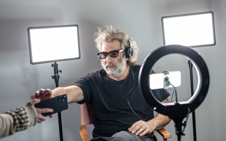 Radio host, charming influencer, records a live show with camera stuff and equipment.の写真素材
