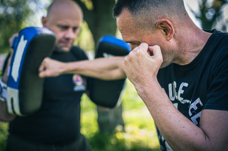 Muay thai trainer holds focus mitts. Kick boxing training and demonstration with pads. Martial arts practiceの写真素材