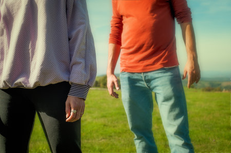 Man and woman, young couple standing in front of each other in nature. A nice sunny day in spring or autumn.の写真素材