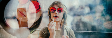 Influencer young woman recording video on smartphone and lighting herself with ring lamp. Broadcast communicates with followers in social networks.の写真素材