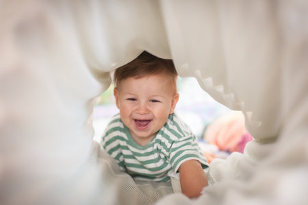 Cute happy laughing baby crawling through play tunnel. Child  development. Happiness and people conceptの写真素材