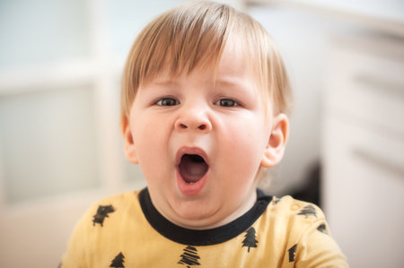 Portrait of sleeping beautiful and yawning baby toddler waiting time for bed. Happy carefree childhoodの写真素材