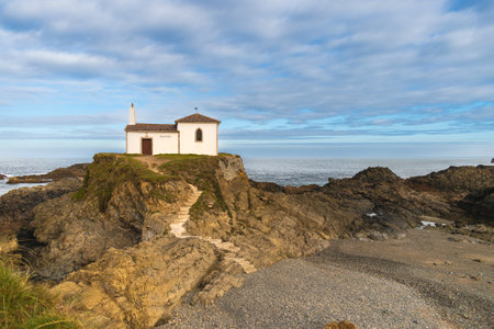 In the photo you can see a hermitage on top of some cliffs in the town of ValdoviÃ±o, Galicia, with a blue sky with clouds.の写真素材