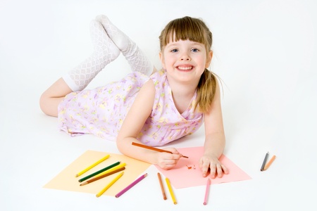Cute child draw with colorful crayons and smile, isolated over whiteの写真素材