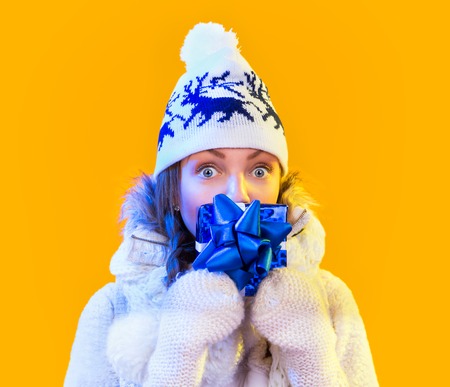 Christmas Woman. Beautiful New Year and Christmas Gift Holiday Hairstyle and Make up. Beauty Girl with Colorful Makeup, Hair, Gift and Accessories. Happy and funny Woman. Emotions. Yellow backgroundの写真素材