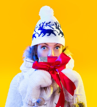 Christmas Woman. Beautiful New Year and Christmas Gift Holiday Hairstyle and Make up. Beauty Girl with Colorful Makeup, Hair, Gift and Accessories. Happy and funny Woman. Emotions. Yellow backgroundの写真素材