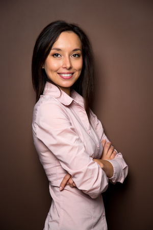 Business woman portraiton brown background. Crossed arms.の写真素材