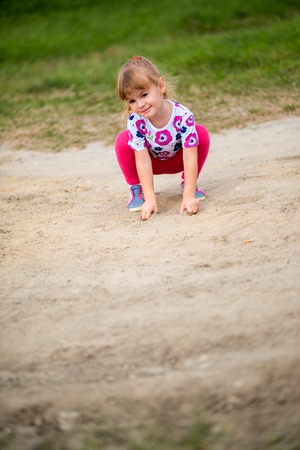 Happy little girl climbing on outdoor playgroundの写真素材