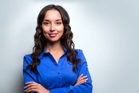 Smiling business woman blue suit dressed standing against white background with crossed arms. Copy space.の写真素材
