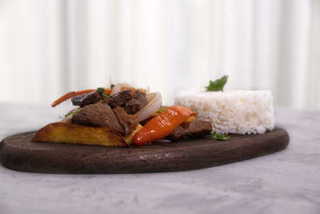 Peruvian dish known by the name of lomo saltado, prepared with pieces of beef tenderloin, tomatoes, yellow pepper, peppers, onion and other vegetables.の写真素材