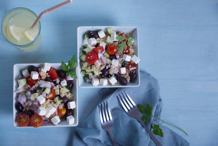 Greek salad in square plates and lemonade on a light blue background.の写真素材