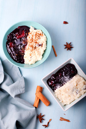 Typical Peruvian dessert: rice pudding and purple mazamorra on a light blue background.の写真素材