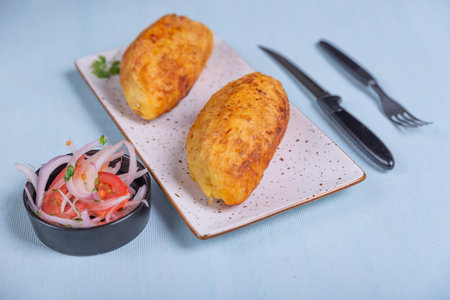 Creole dish called stuffed potato a crispy potato with a meat filling inside, accompanied by an...