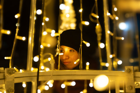 A woman looks out at the Christmas lights in her town.の写真素材