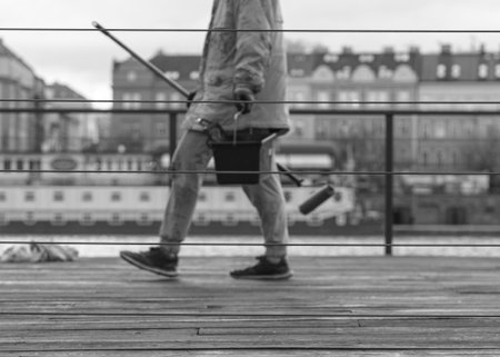 A man with a bucket in his hands stands on a wooden pier.のeditorial素材