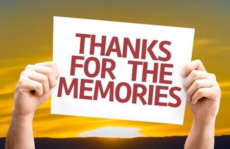 Hands holding Thanks for the Memories card with sunset backgroundの写真素材