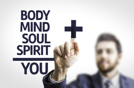 Business man pointing the text Body/Mind/Soul/Spirit = Youの写真素材