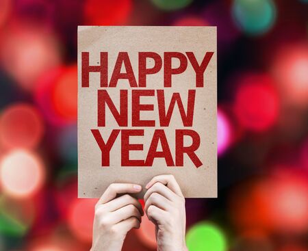 Hands holding cardboard with Happy New Year on bokeh backgroundの写真素材