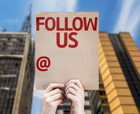 Cardboard with Follow Us text on city backgroundの写真素材