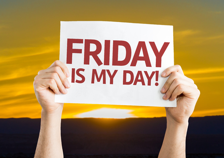 Hands holding Friday Is My Day card with sunset backgroundの写真素材
