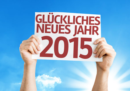 Hands holding Happy New Year 2015 (In German) card with a beautiful day