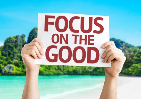 Hands holding Focus on the Good card with beach backgroundの写真素材