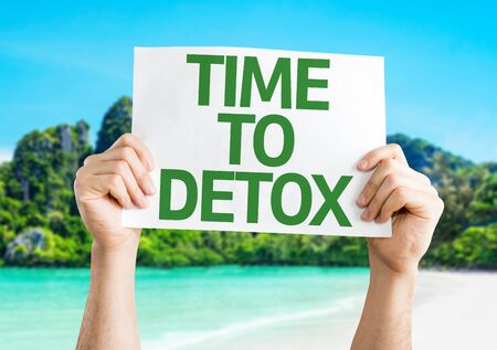 Hands holding Time To Detox card on beach backgroundの写真素材