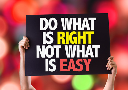 Hands holding card with text Do what is right not what is easy on bokeh backgroundの写真素材