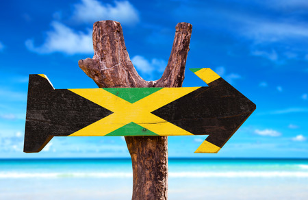 Jamaica flag sign with arrow on beach backgroundの写真素材