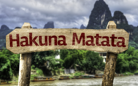 Wooden sign board in wetland with text: Hakuna Matata (no worries in Swahili)の写真素材