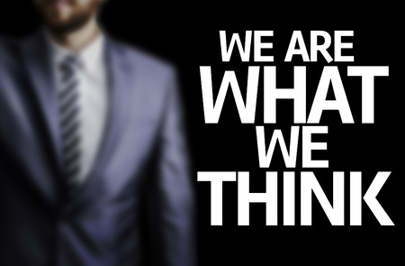 Business man in black background with the text: We are what we thinkの写真素材