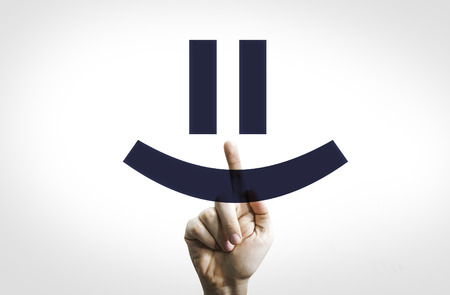 Hand pointing to transparent board with a smiley faceの写真素材