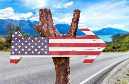 USA flag sign with arrow on road backgroundの写真素材