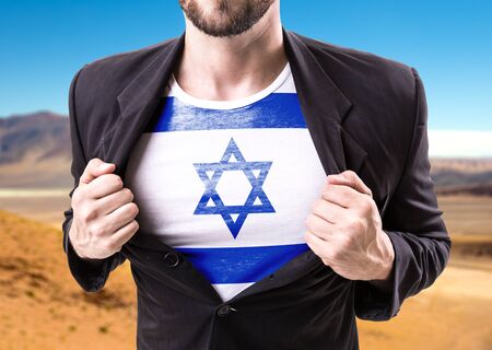 Businessman stretching suit with Israel flag on desert backgroundの写真素材
