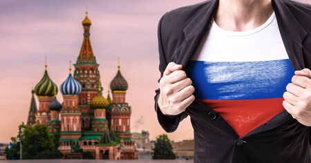 Businessman stretching suit with Russia flag with St. Basils Cathedral backgroundの写真素材