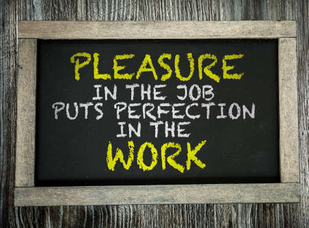 Pleasure in the Job Puts Perfection in the Work written on chalkboardの写真素材