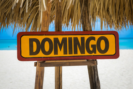 Sunday in SpanishPortuguese sign with beach backgroundの写真素材