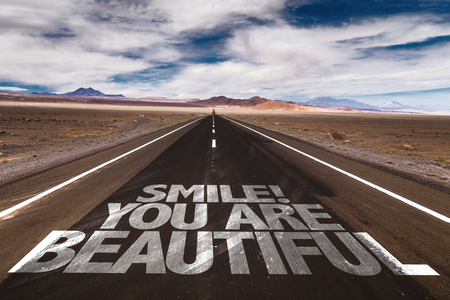 Smile! You Are Beautiful written on desert roadの写真素材