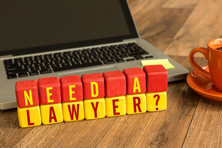 Need a Lawyer written on a wooden cube in front of a laptopの写真素材