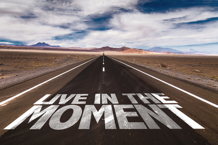 Live in the Moment written on desert roadの写真素材