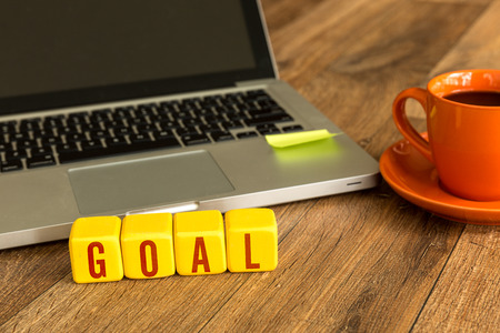 Goal written on a wooden cube in front of a laptopの写真素材