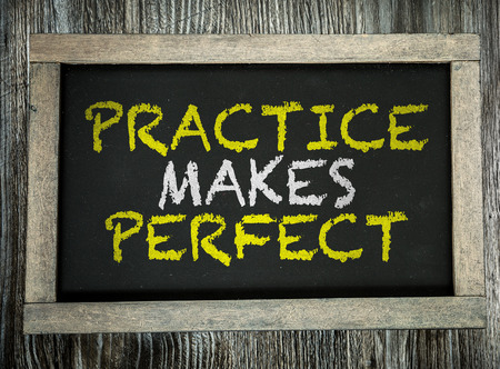 Practice Makes Perfect written on a chalkboardの写真素材