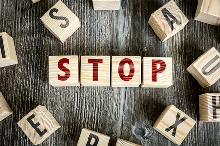 Stop written on a wooden cube backgroundの写真素材