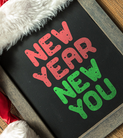 New year new you written on blackboard with santa hatの写真素材