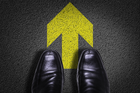 Text on road with business shoes background: Arrow upの写真素材