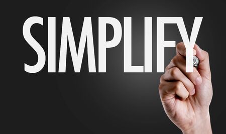 Hand holding a marker with Simplify conceptの写真素材