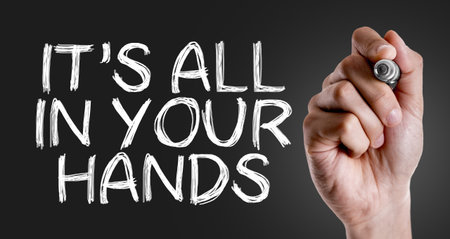 Hand holding a marker with Its All In Your Hands